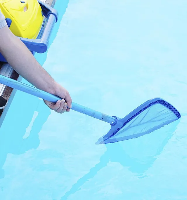 Persona realizando mantenimiento a piscina